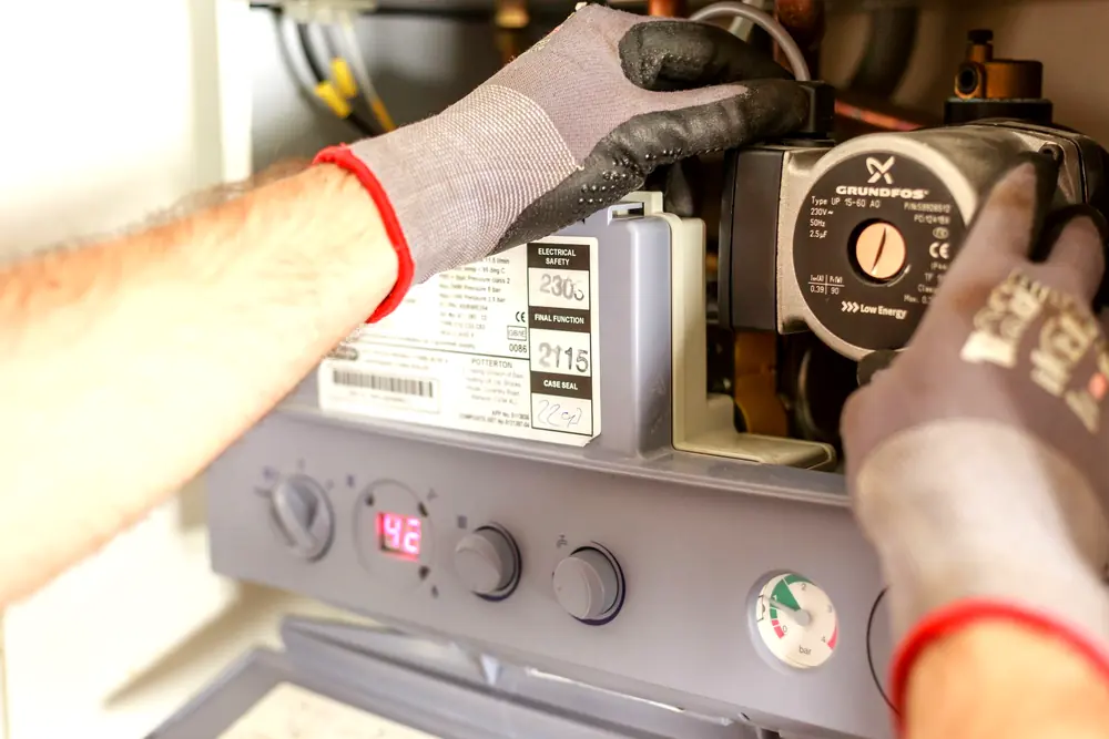 Wilson Family technician doing careful, hands-on plumbing and heating work